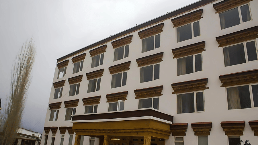 Low-angle shot of the facade and a roofed entrance of Hotel Dekiling by Eastlynn Collections, Leh, under an overcast sky.