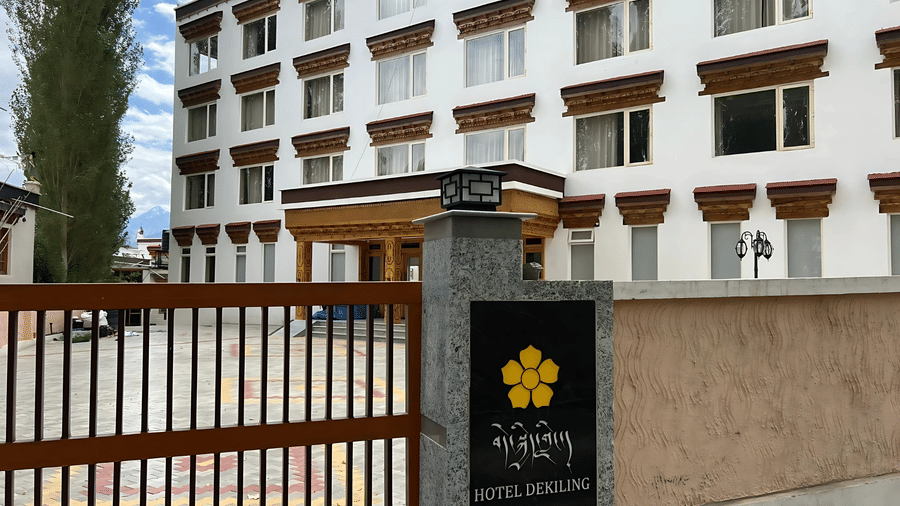 Exterior view of the white hotel building and gated entrance with the official signage for Hotel Dekiling by Eastlynn Collections, Leh.