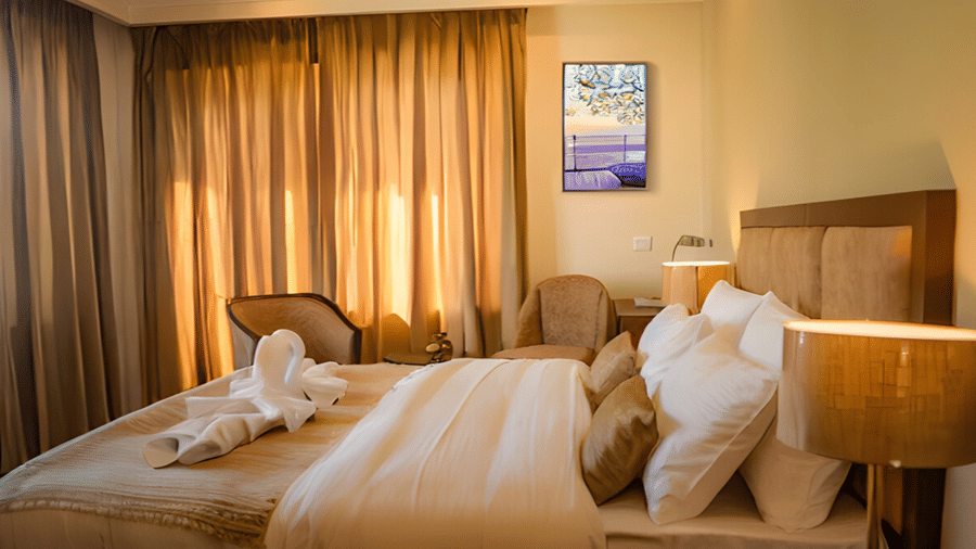 A warm, well-lit Family Suite at Hotel Dekiling by Eastlynn Collections, Leh, featuring a large bed with linens and gold accents.