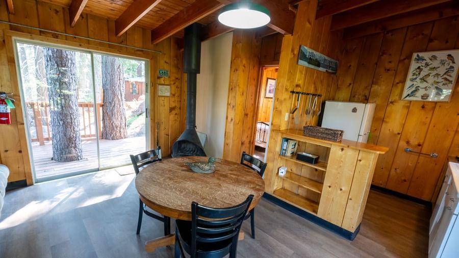 Cabin kitchen and dining space with wood stove and natural light at Kit Carson Lodge.