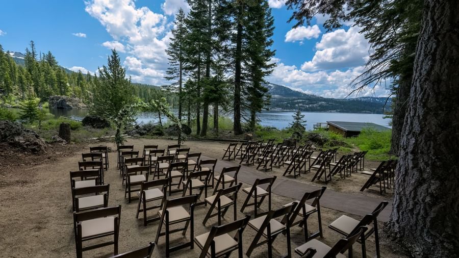 Lakefront outdoor event seating under trees at Kit Carson Lodge.