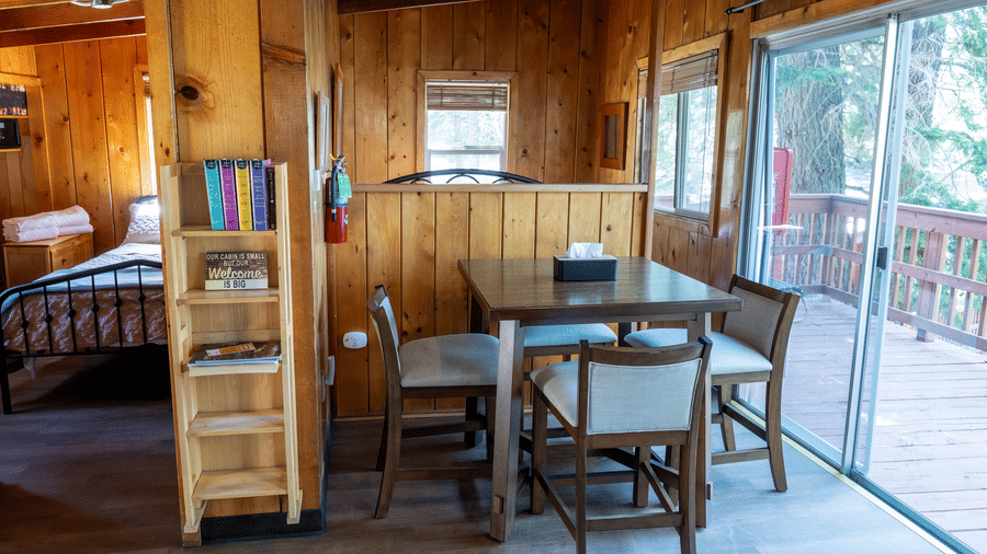 Dining area with sliding glass doors leading to the deck and forest views at Kit Carson Lodge
