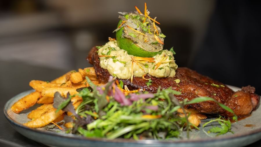 Gourmet dish with steak, vegetables, and mashed potatoes topped with herbs served at Narrow Gauge Inn.