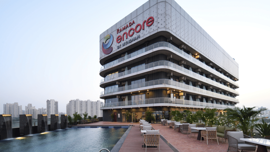 Hotel exterior view with modern architecture and landscaped open area | Ramada Encore by Wyndham Gurugram Dwarka Expressway
