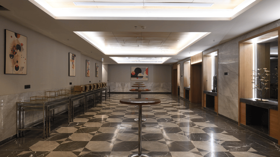 Spacious pre-function area with service tables and walkway for guest movement | Ramada Encore by Wyndham Gurugram Dwarka Expressway