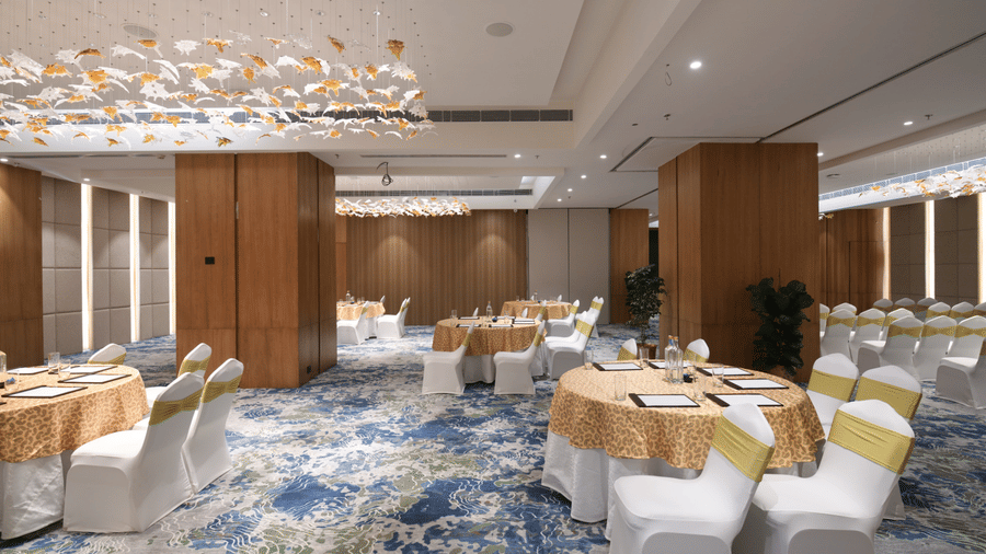 Event space arranged with round tables suitable for conferences or social functions | Ramada Encore by Wyndham Gurugram Dwarka Expressway