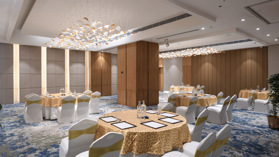 Banquet hall arranged with round tables for meetings, events, or formal gatherings | Ramada Encore by Wyndham Gurugram Dwarka Expressway