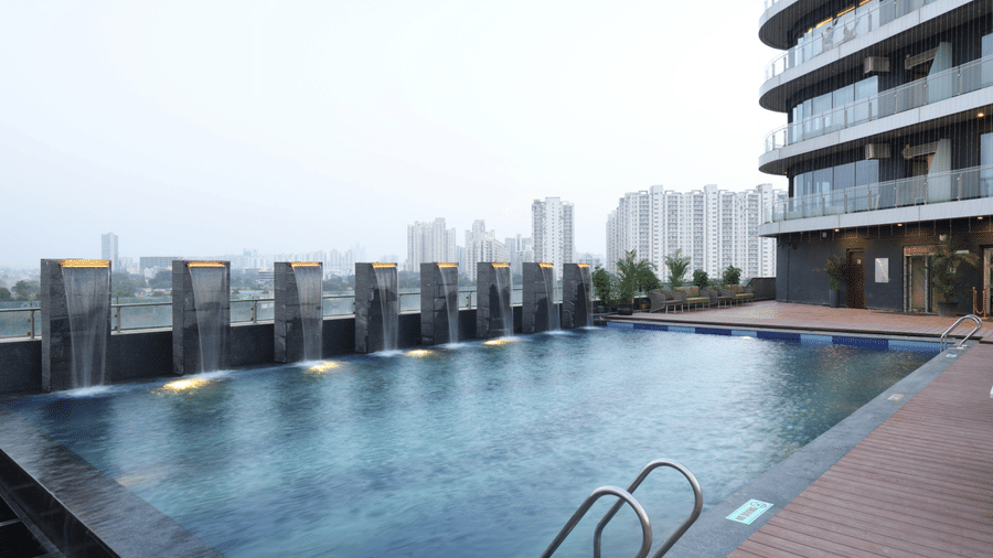 Rooftop pool area with infinity edge and modern urban surroundings | Ramada Encore by Wyndham Gurugram Dwarka Expressway