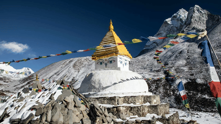 A white temple building sits on a snow-covered mountain.