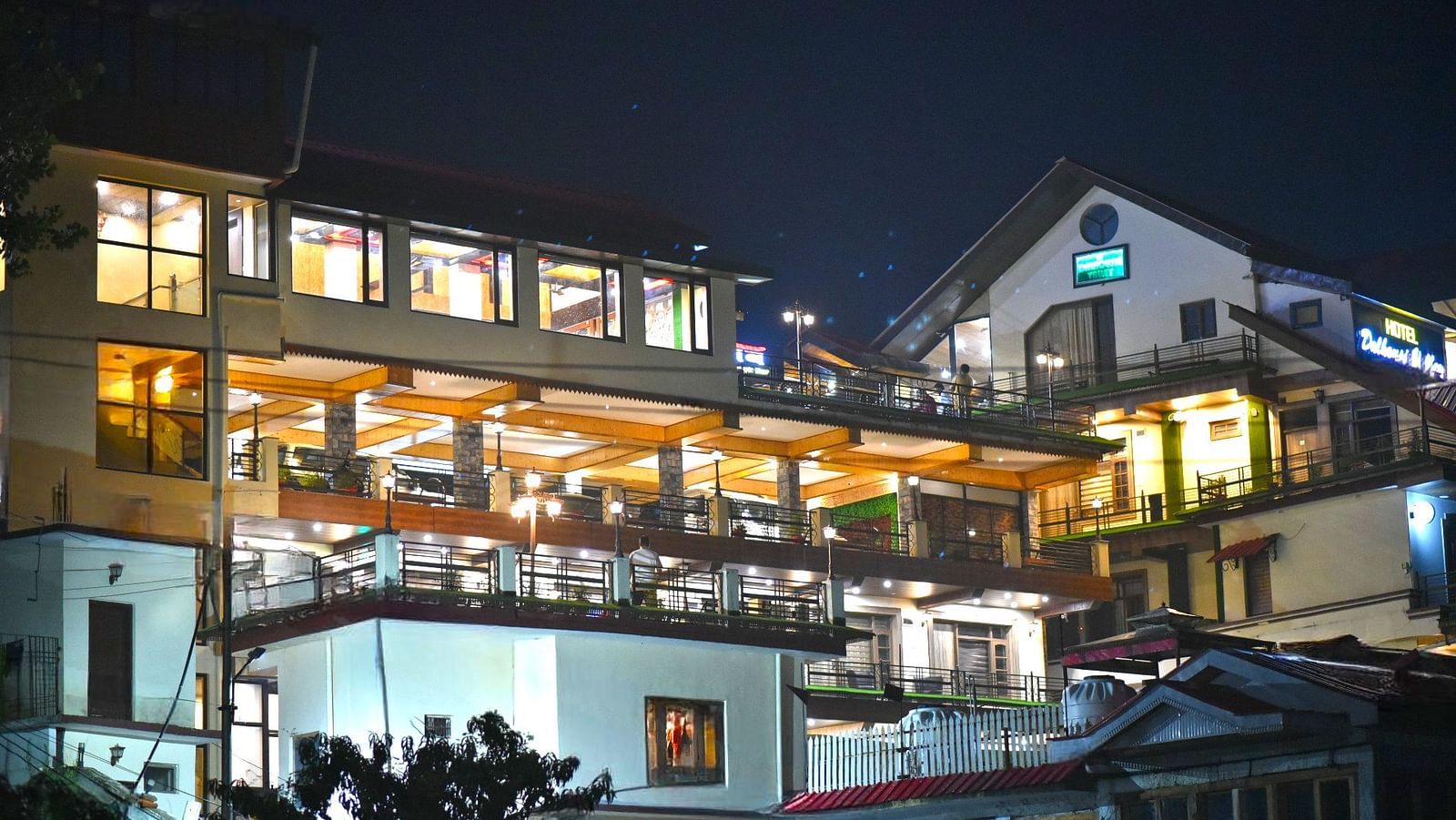 Facade image with warm lighting of DLS Dalhousie Valley Resort taken at night.
