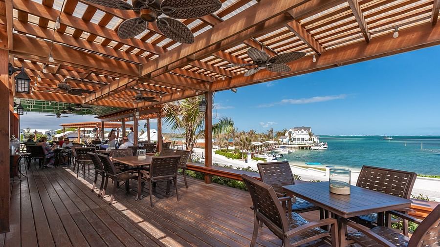 Covered outdoor restaurant seating with ocean in the background | Abaco Inn