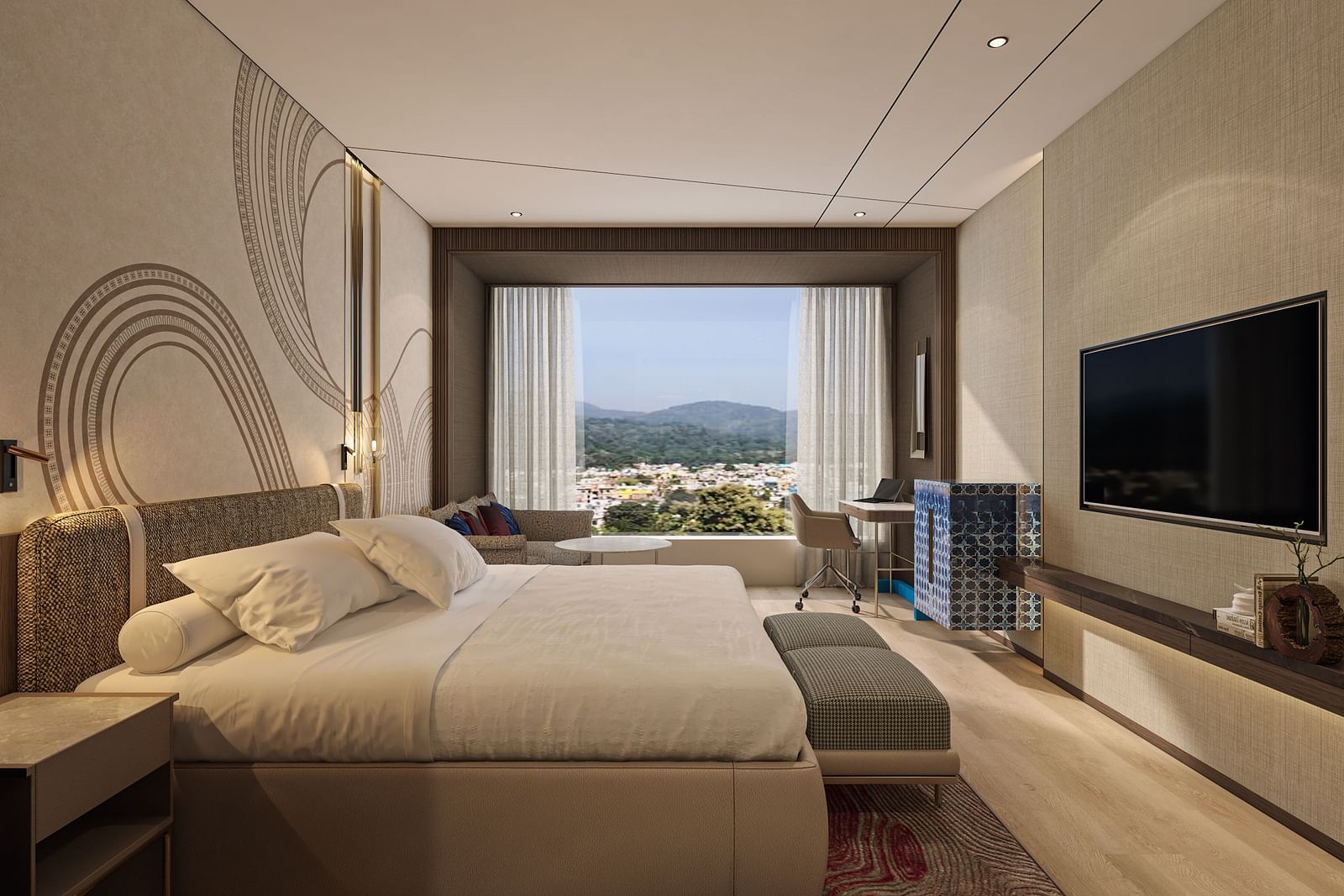 A side wide view of a double bed room with TV, rug, work desk and chair with a window overlooking an outside view