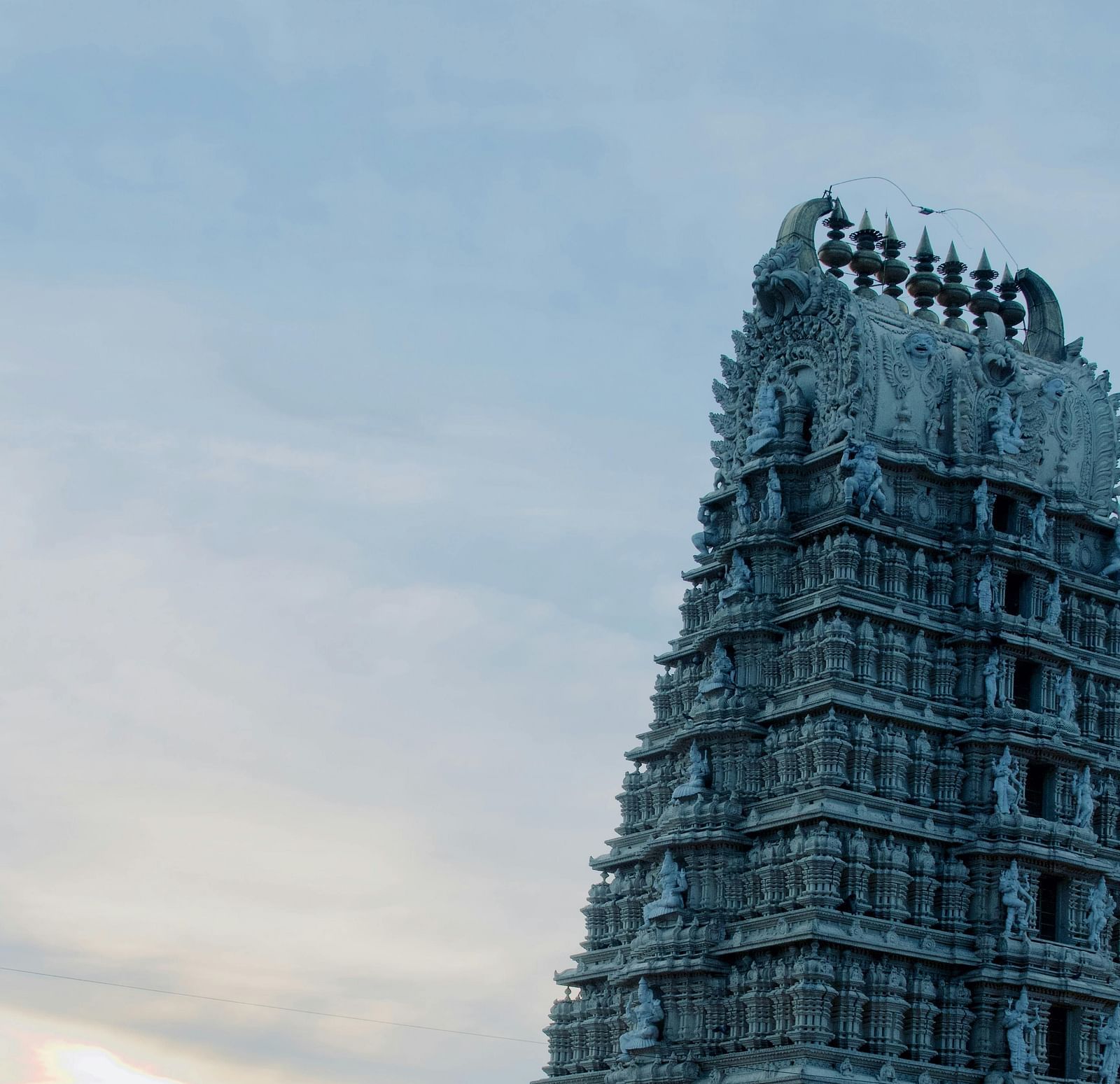 A view from below of a temple's roof with intricate architecture on it.