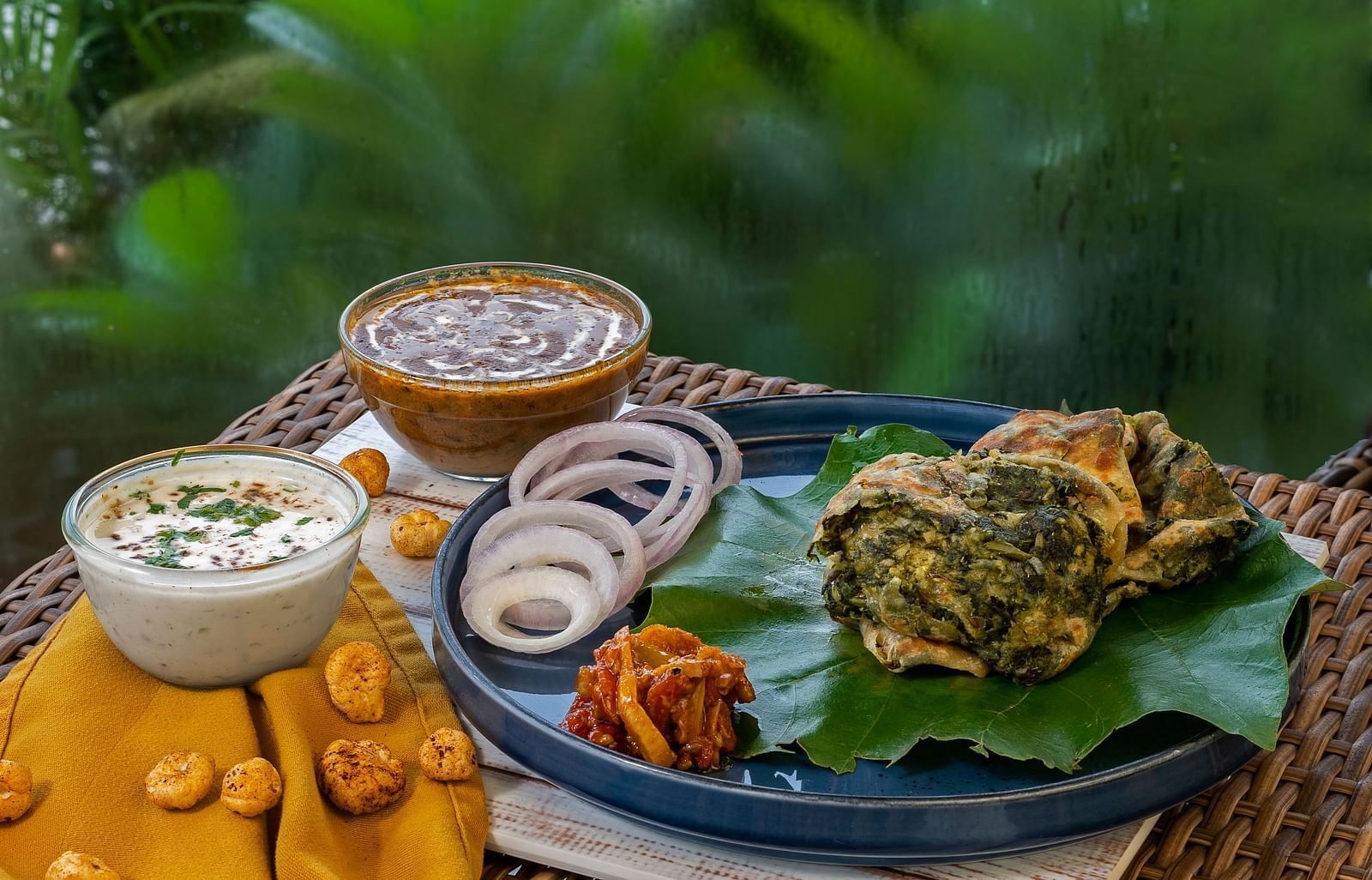 Traditional South Indian platter at The Patio café, Haridwar featuring appam, chutneys, and leafy greens served on a banana leaf.