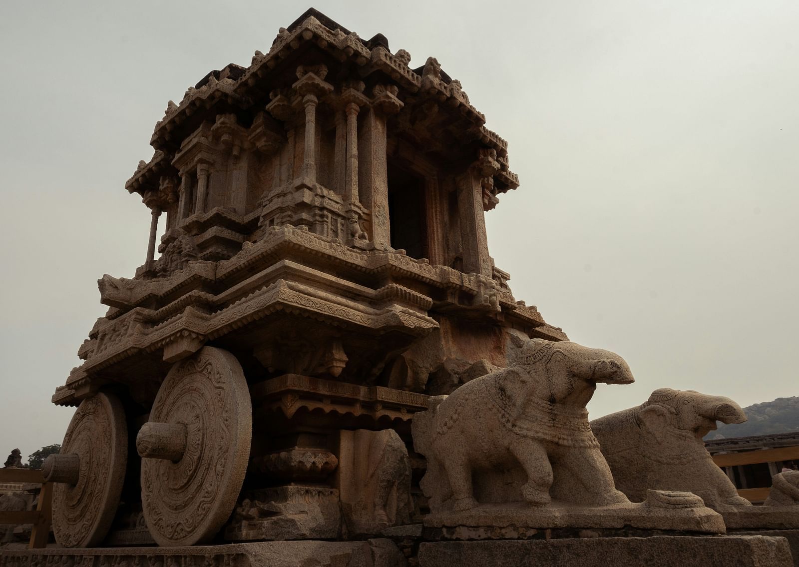 An overview of a stone chariot intricately carved from a rock as seen from below.