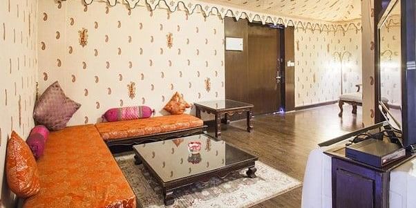 Image of a room with seating area and a table in front at Rajasthali Resort & Spa Jaipur.