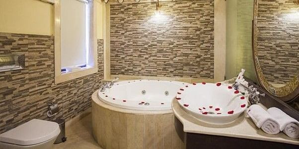 Image of washroom with a jacuzzi decorated with rose petals Rajasthali Resort & Spa Jaipur.