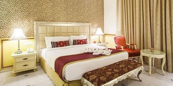 Image of a room with a bed, side tables and a chair at Rajasthali Resort & Spa Jaipur.