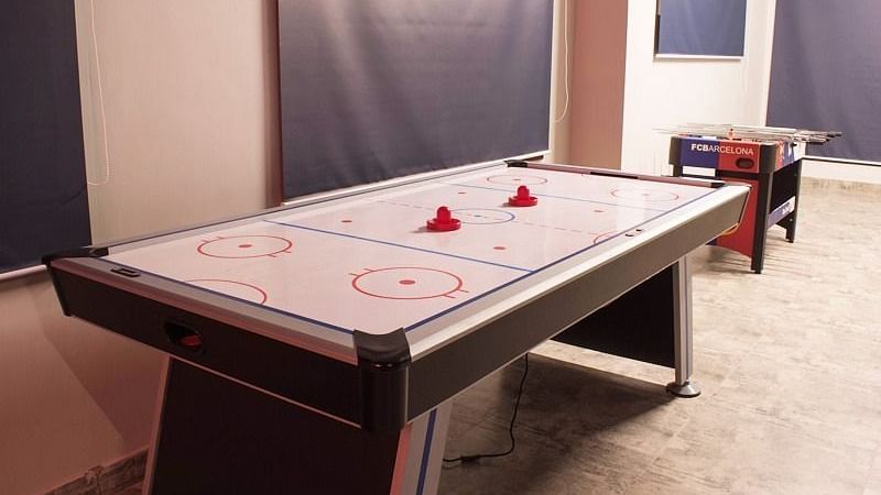 An air hockey table with two mallets placed on top at DLS Forest Vines Resort & Spa, Ramnagar (Jim Corbett).