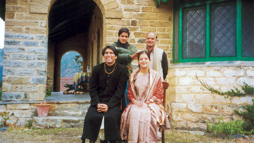 A couple after their Kumaon Wedding in front of Old Bungalow with family members behind them - Ramgarh Bungalows, Nainital.