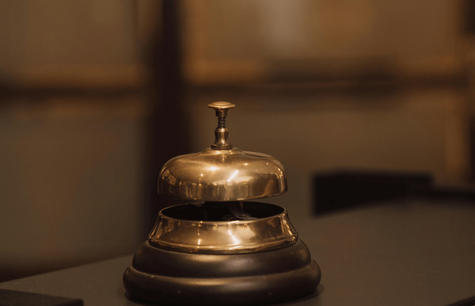 A metal service bell placed on a polished counter.