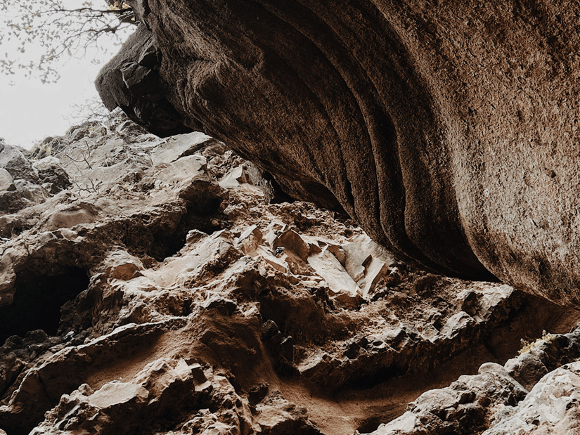A naturally formed rock cave featuring rugged stone textures, unique formations, and an adventurous atmosphere.