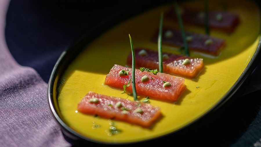 image featuring small chunks of fish served in yellow gravy topped with micro greens - Maikhao Dream Villa Resort & Spa, Phuket