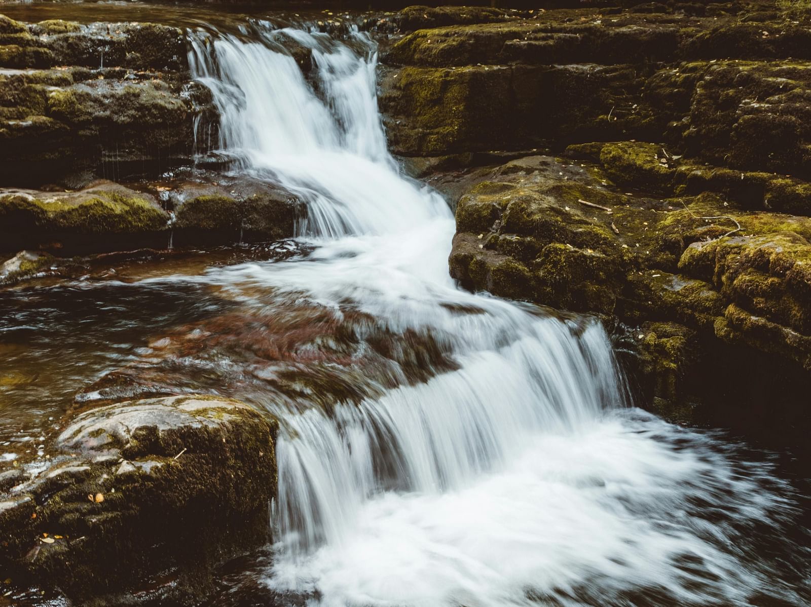 A view of waterfalls cascading through  a rocky area.