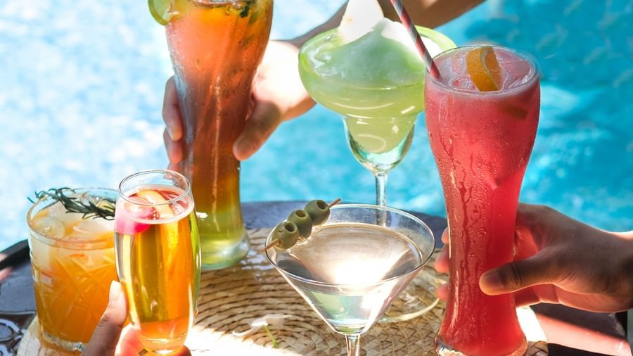 Summer cocktails being toasted by friends at a sunny poolside location | Mango Hill, Pondicherry