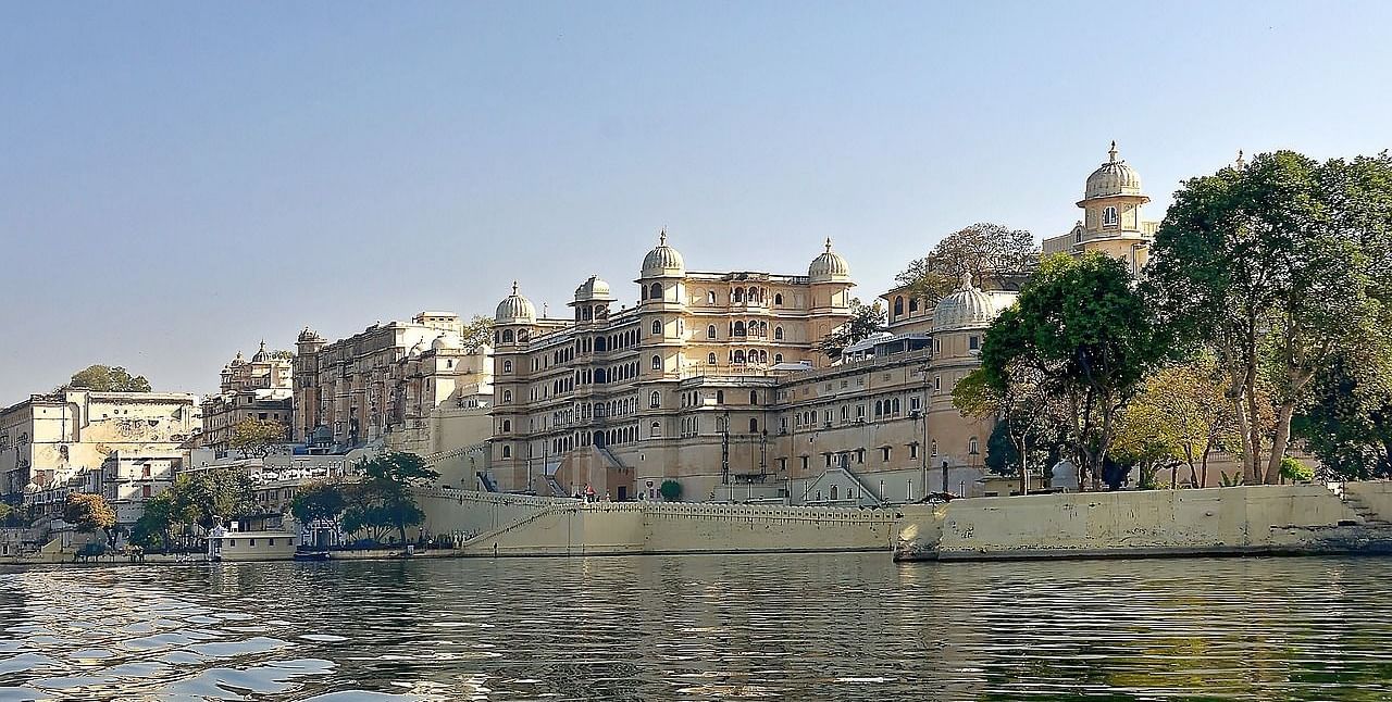 A lower angle view of a palace from the lake point with clear blue sky in the background.