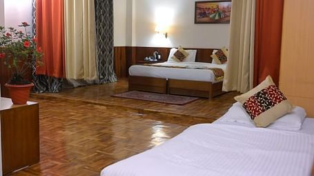 An image of the family room featuring two beds, bed side tables, indoor plants, and decorative lighting - Sumitel Chiminda, Pelling