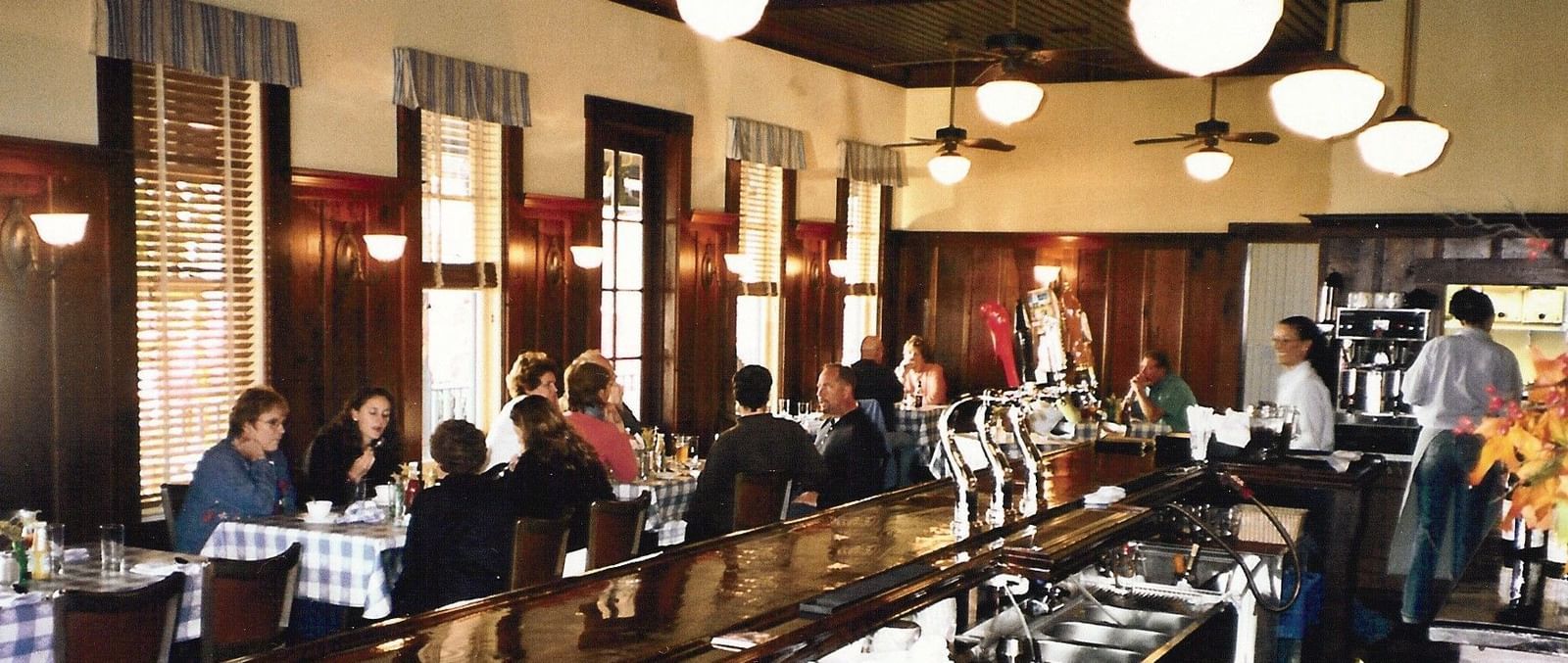 Guests enjoy drinks and conversation at the lively bar and dining area within the Tallman Hotel.