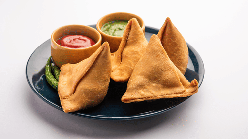 Deep fried samosas with chutney and sauce