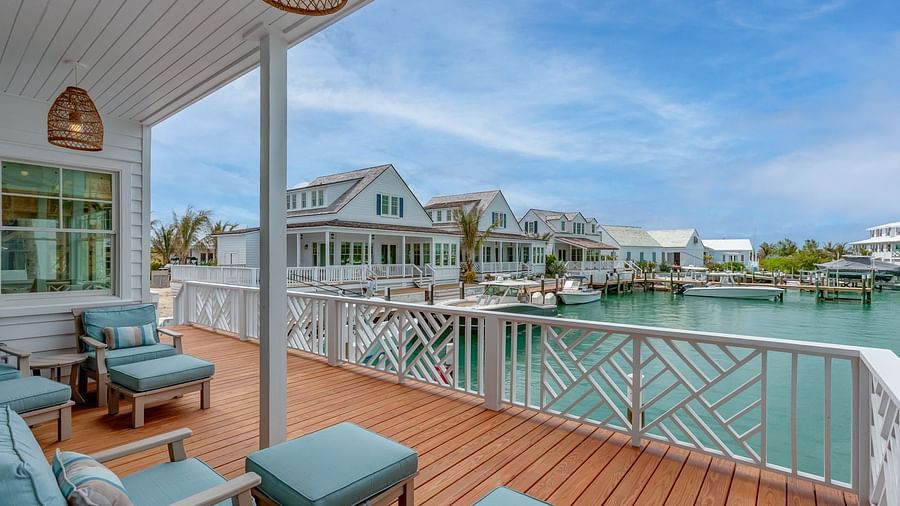 Waterfront deck with cushioned seating and a covered patio area | Abaco Inn