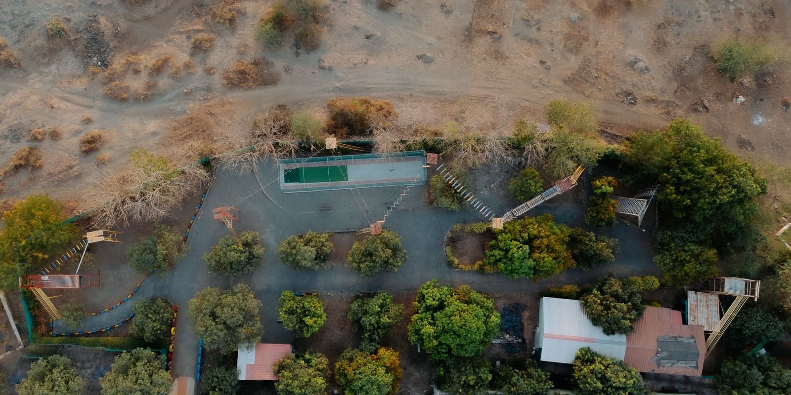 An aerial view of Daksh Resort & Amusement Park, Sasan Gir, featuring the greenery surrounding the resort.