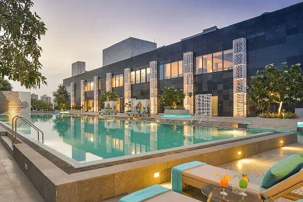 Outdoor pool area lit in the evening next to the building at Karma Chalets.