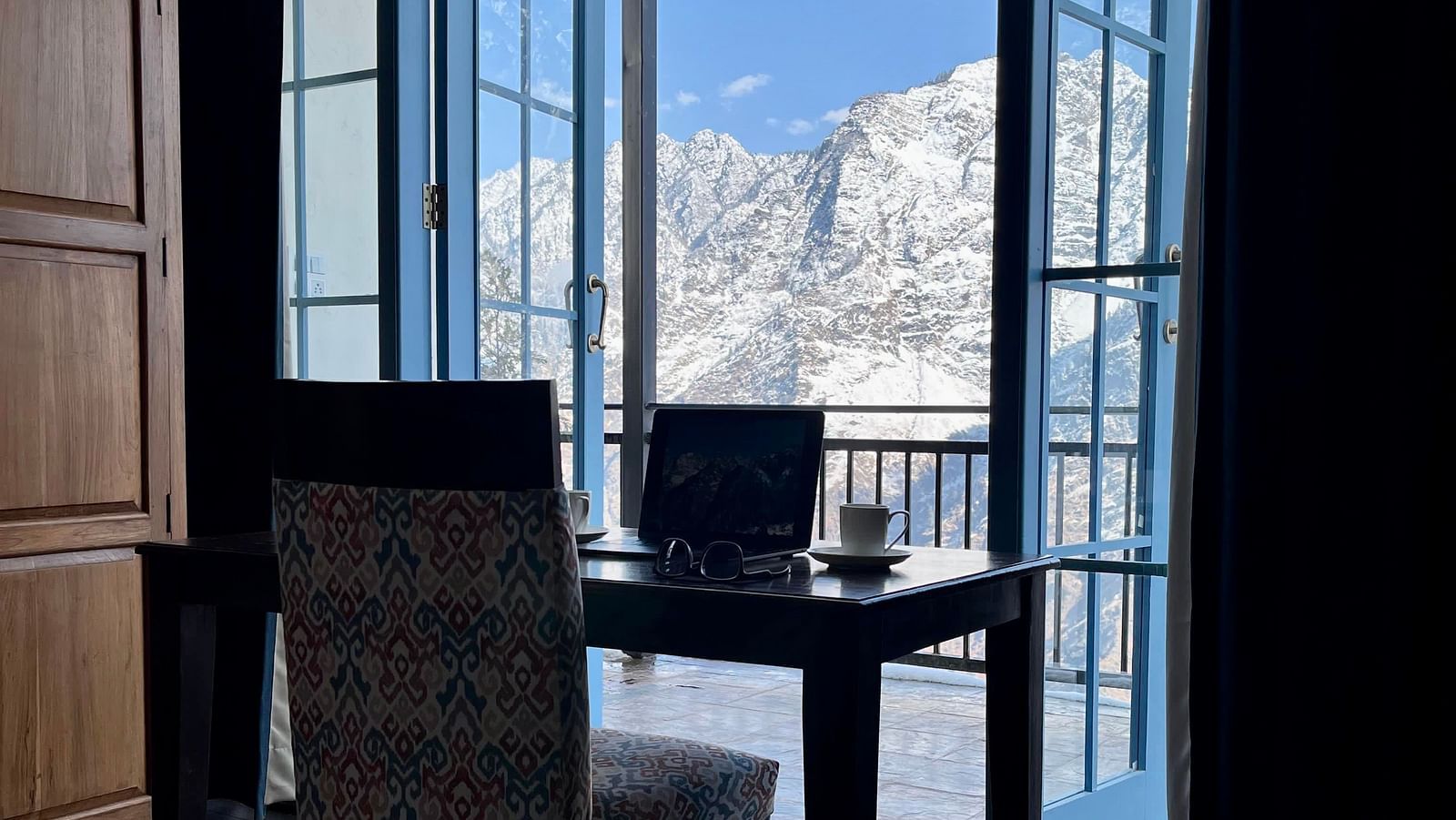 Image of a living room with working space with laptop on the table | Faraway Cottages, Auli