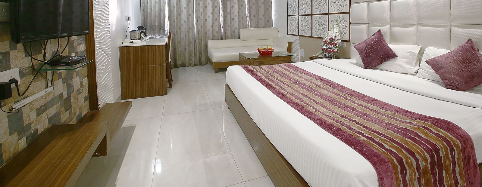 A sophisticated room with plush bedding, a cosy seating area, and contemporary aesthetics - Hotel Emerald, Chandigarh
