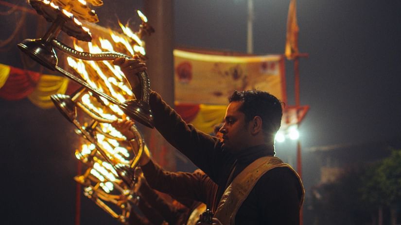 a closeup shot of priests performing the arti by the bank of Sangam