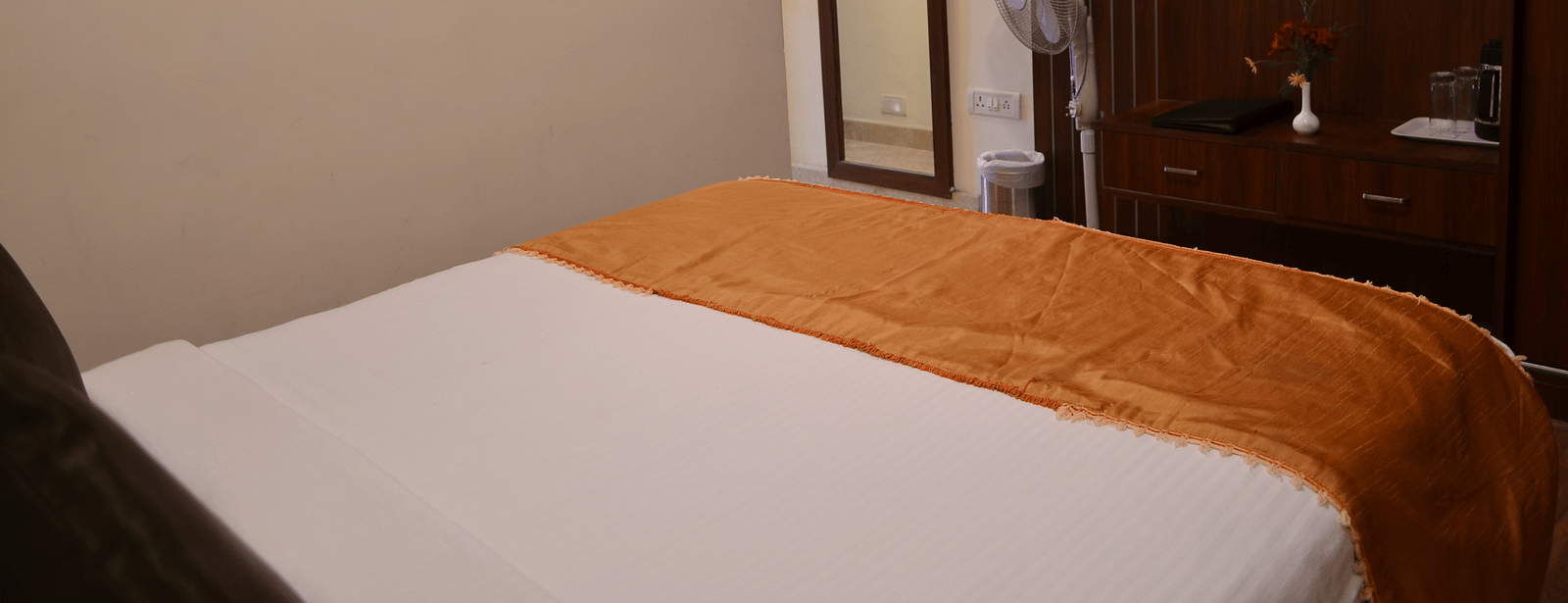 A simple room with a single bed, TV, and ambient lighting for a restful solo stay - Benzz Park, Kodaikanal