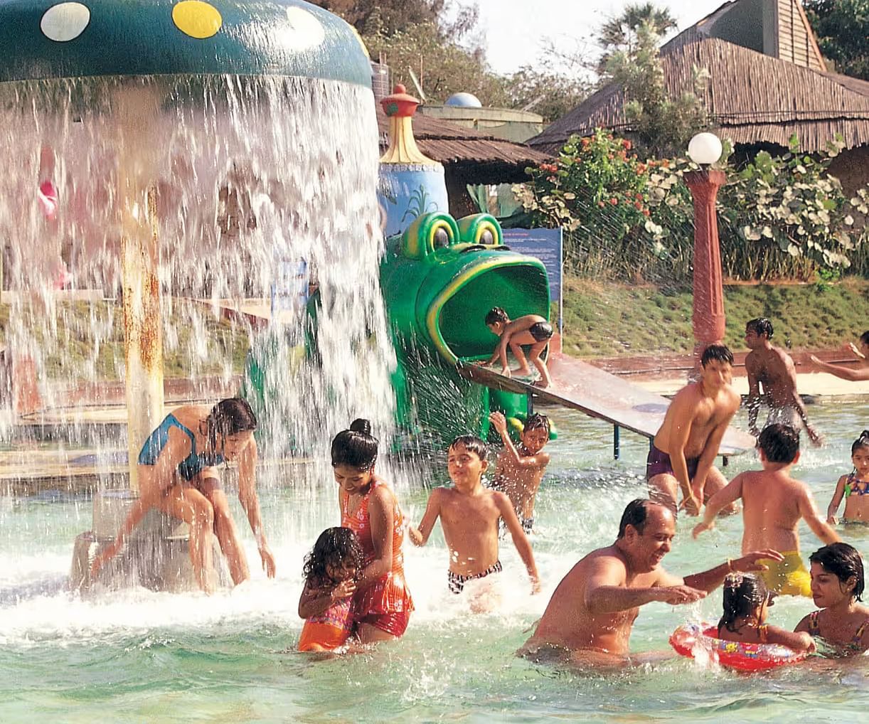 Kids with adults enjoying Frog Slide at Water Kingdom in the water