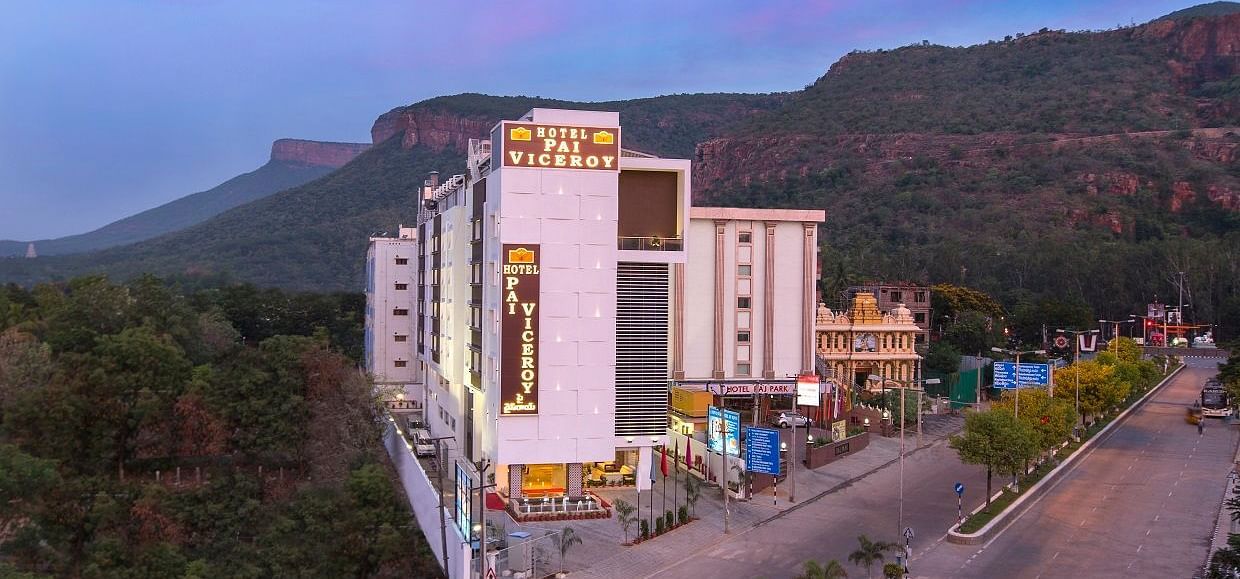 A image of a Hotel Pai Viceroy Tirupathi builiding which is set amidst the hills and greenery 
