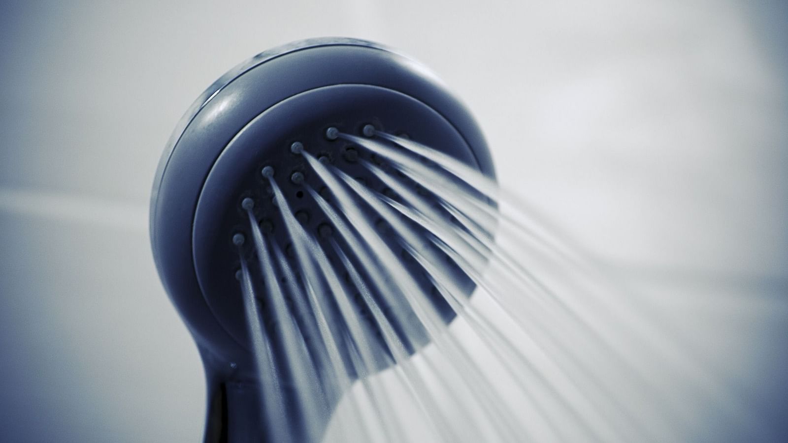 Image of a shower head with water flowing out of it.