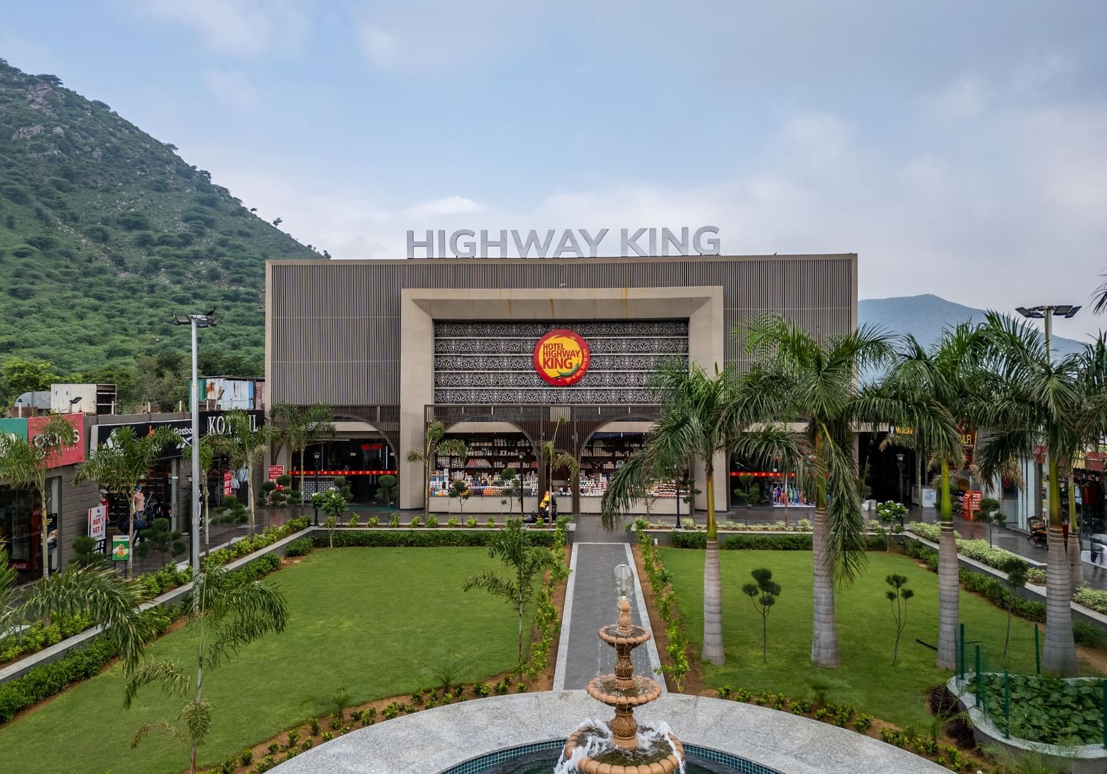 Landscaped front garden and exterior view of the main restaurant building at Hotel Highway King, Neelka.