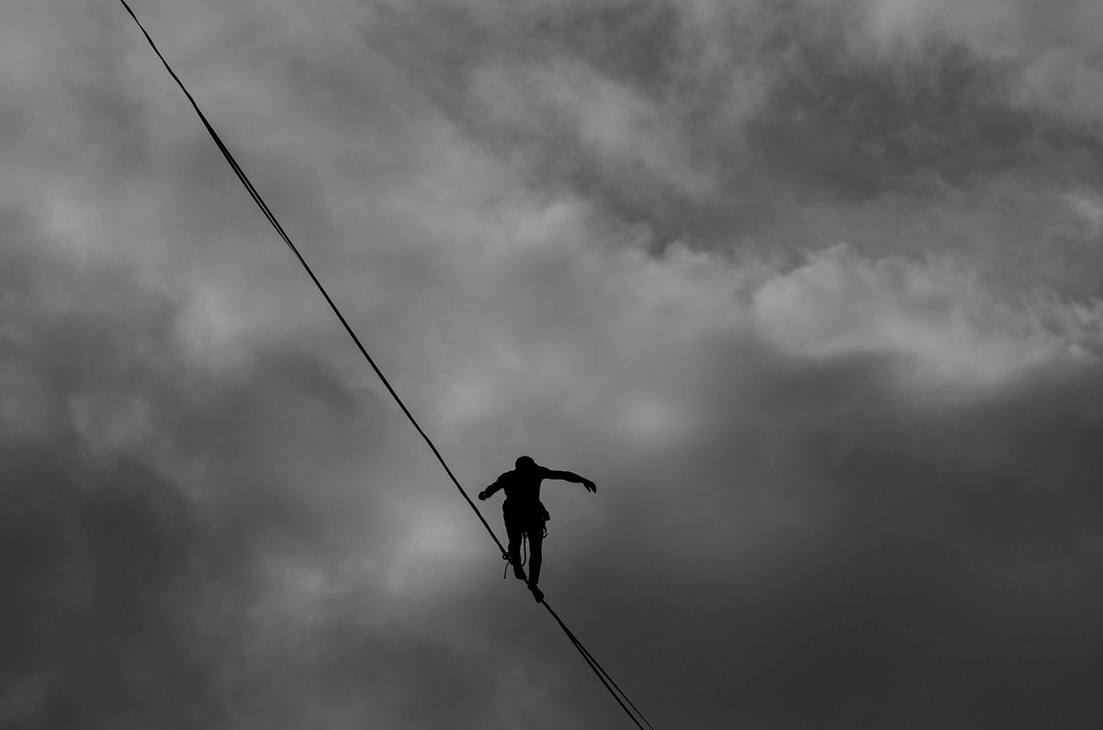 A person balancing on a rope suspended in mid-air.