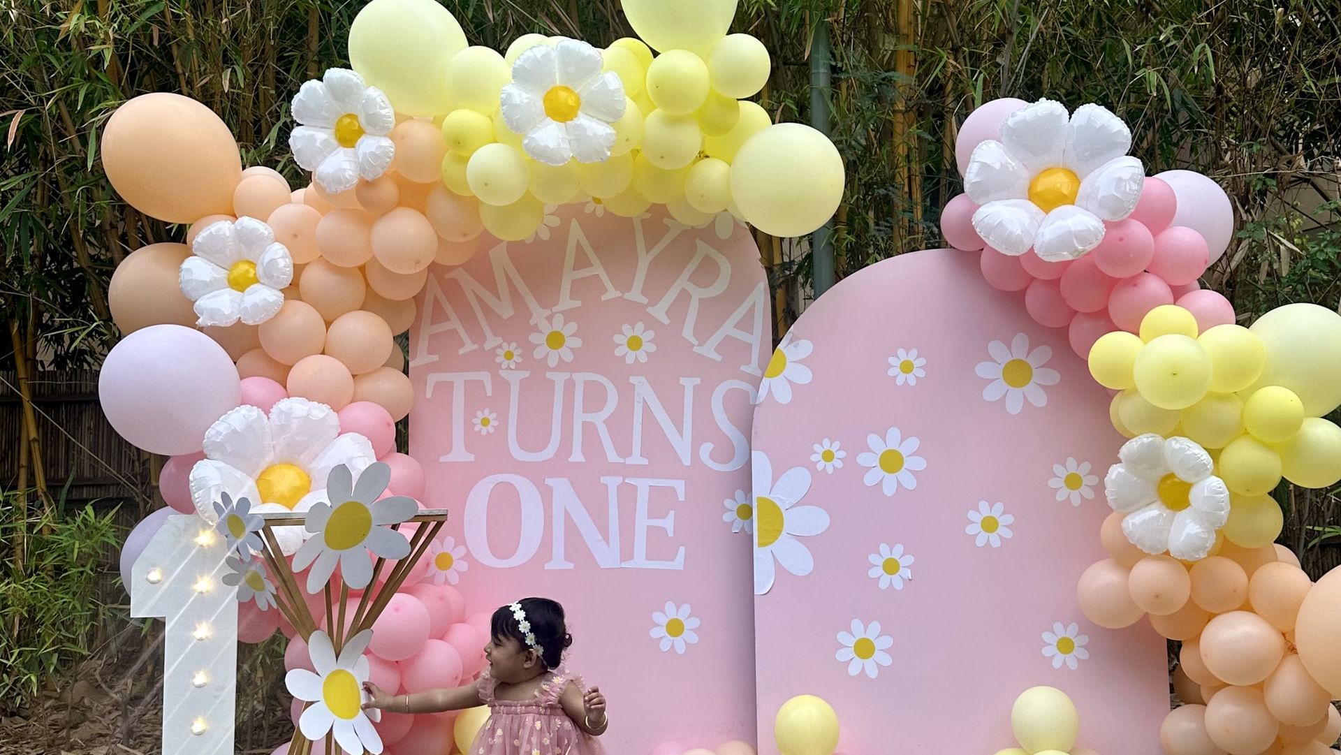 Pastel balloon arch with decorative props set up outdoors for a celebration at Karma Chalets.