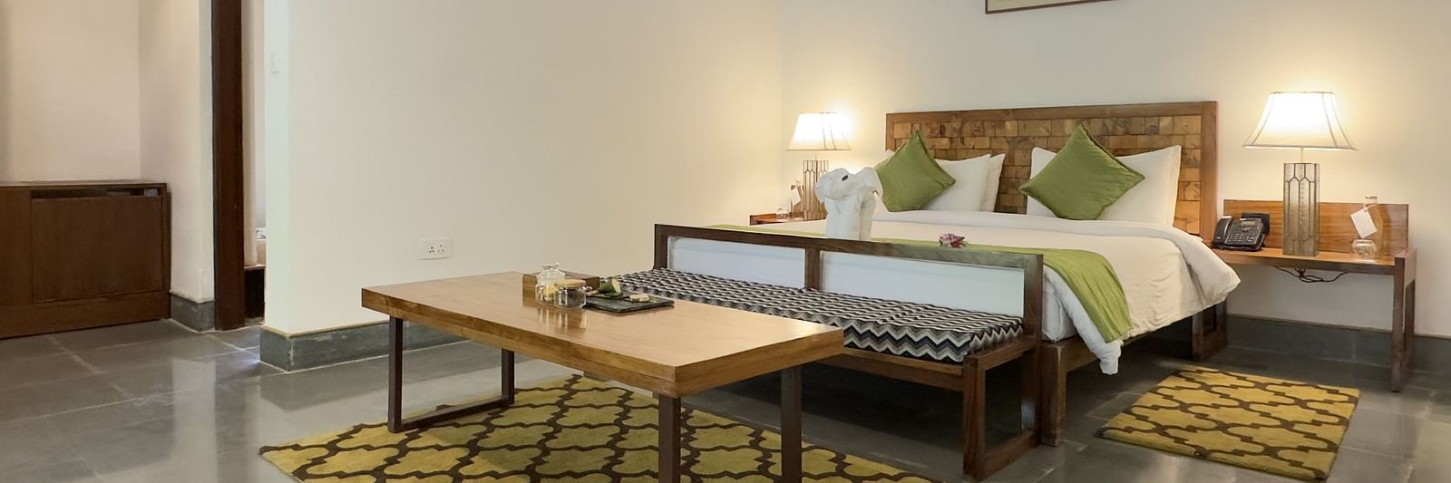 Sanctuary Suite at Saraca Resort & Spa Corbett with a double bed and a coffee table placed in front of the bed on a carpet