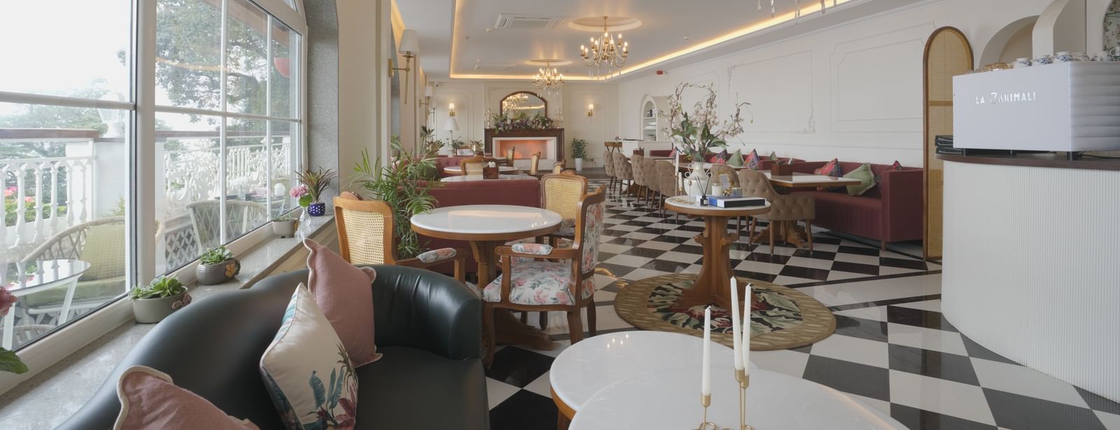 Stylish cafe interior with natural lighting, white tables, and cushioned seating - Mayfair Cafe & Suites, Dalhousie