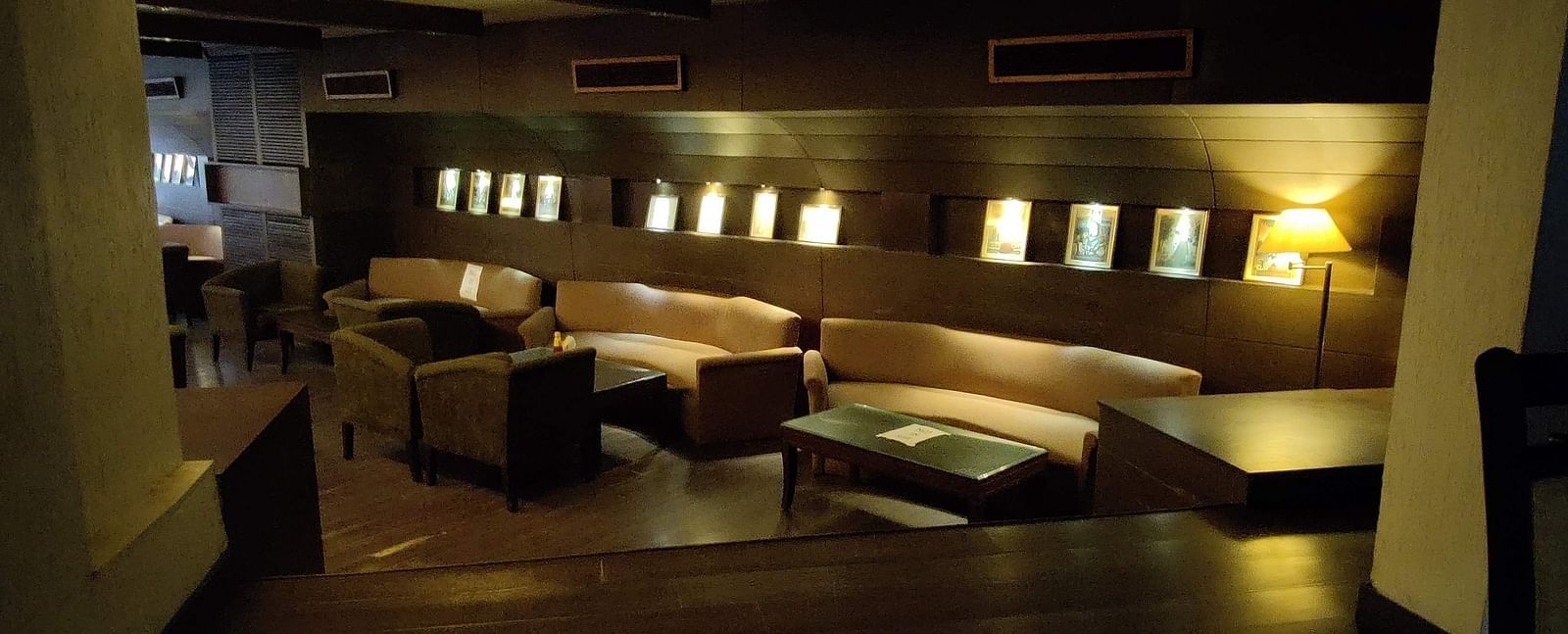 A dimly lit indoor seating area at 24 Karats bar - Hotel Gold, Panipat