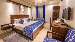 Hotel room at Rockland Hotel, CR Park, with vibrant blue accents, king-size bed, work desk, and modern wooden furnishings.